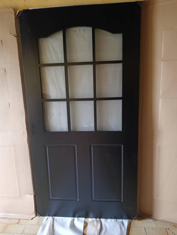 Black exterior door with nine-lite glass panels and lower raised panels