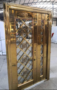 Luxurious ornate gold-finished elevator door with glass panels and intricate crisscross pattern