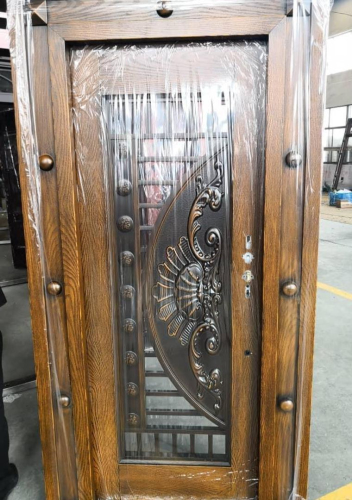 This is a high-grade security door with a wood-grain finish and decorative wrought iron details