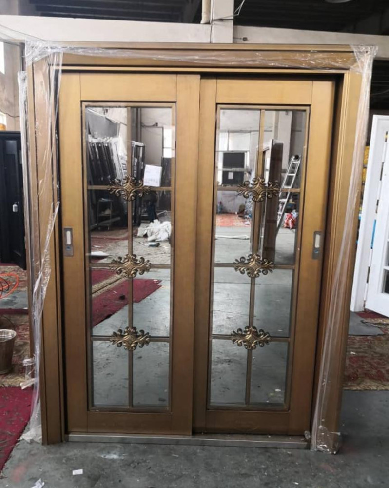 Gold coloured aluminum sliding glass door with decrative metal insert