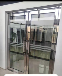 Toughened glass double swing door system with a stainless steel frame and handles