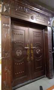 Copper-coloured steel Security Door with an ornate, paneled design
