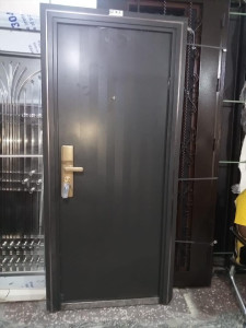 Grey Steel Security Door with a gold-tone handle and lock