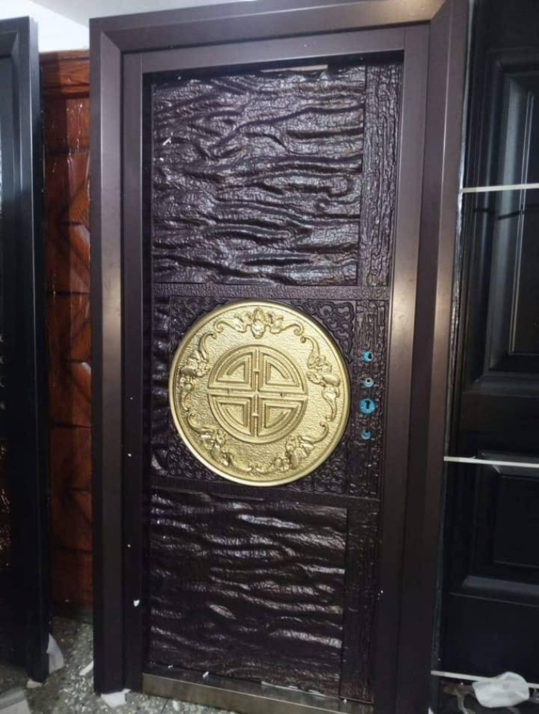 Turkish-style copper cast security entrance door featuring a decorative gold-coloured circular emblem and textured dark metal panels