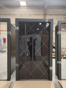 Modern Turkish-style Security Entrance door featuring a dark steel frame and a dark glass panl with a white diamond patterned grid design