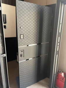 Modern grey steel Security door with a checkered diamond texture pattern and metalic accent bands