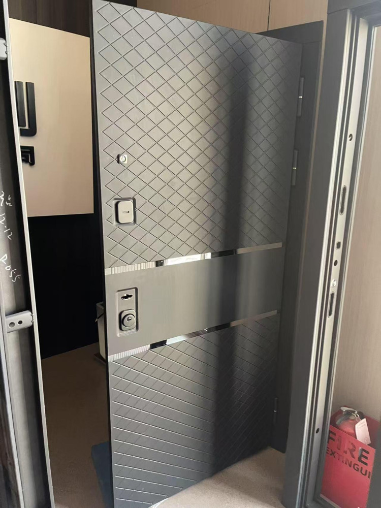 Modern grey steel Security door with a checkered diamond texture pattern and metalic accent bands