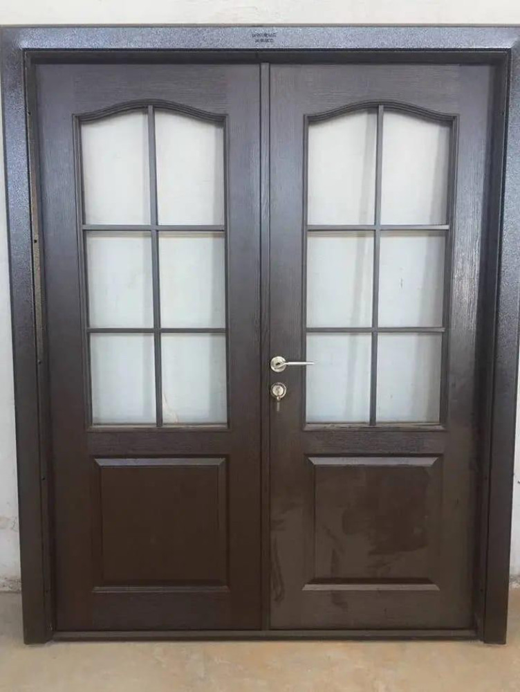 features a double front entry door made of wrought iron with a dark finish and tempered glass panels