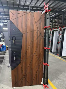 Modern cast aluminum or steel security door featuring a geometric design with a wood grain veneer and blck grooved panels