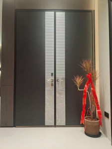 Modern double door design likely for a home interior or exterior entryway, characterized by its sleek dark panels and prominent vertical decorative metal accents