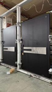 Two large, industrial-style black doors with metalic horizontal handles
